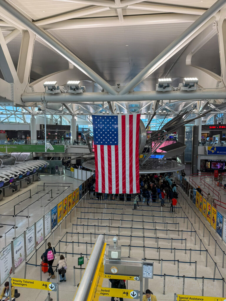 JFK 공항 출국장 전경과 미국 국기