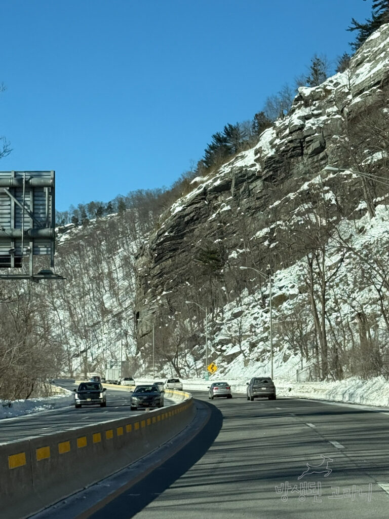 눈 쌓인 산길 옆 도로