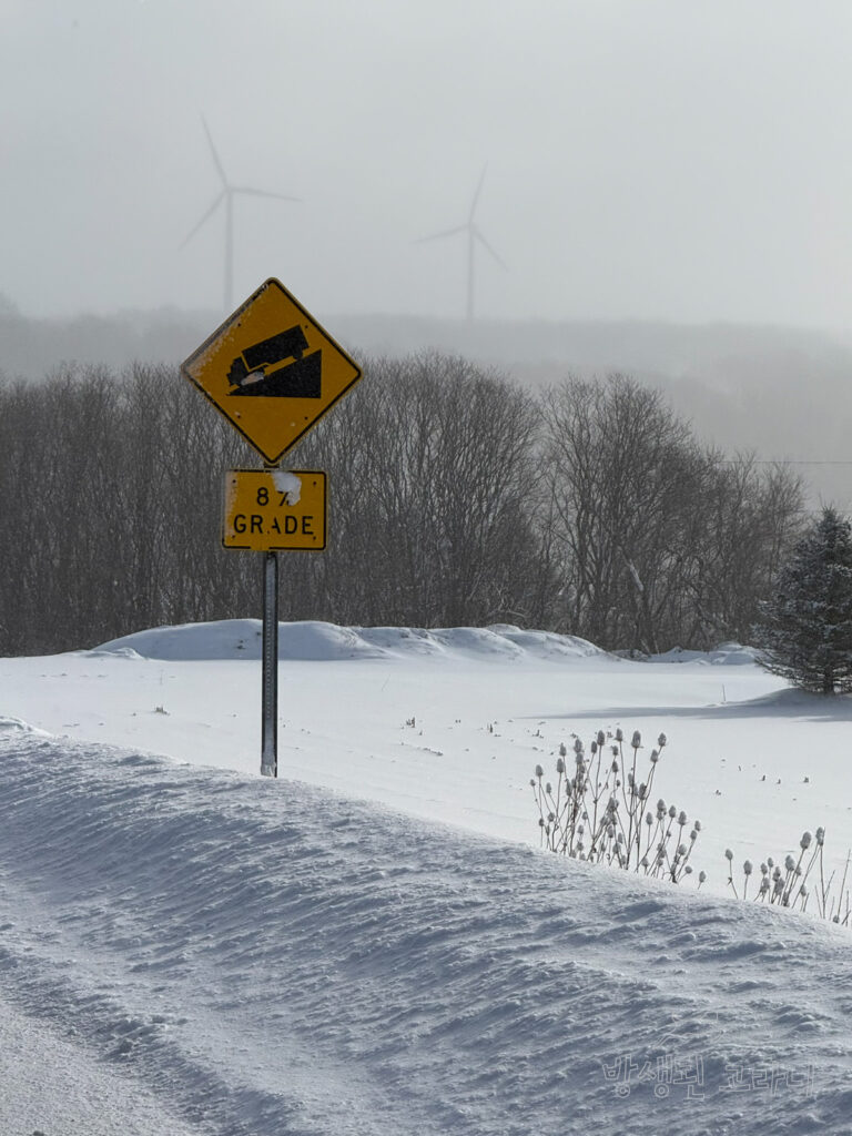 설원과 풍력발전기, 8% GRADE 경사 안내표지판