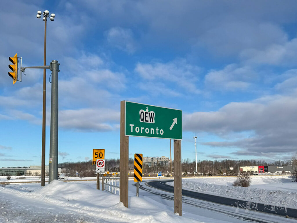 토론토 방향을 가리키는 QEW 고속도로 이정표